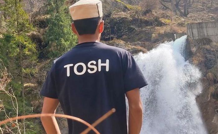 A boy looking at the Tosh Waterfall